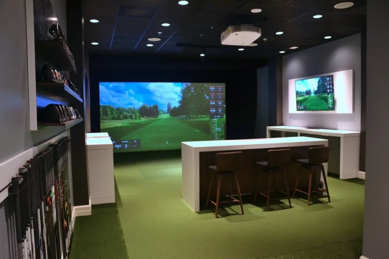 Professional indoor golf coaching area with simulator screens and seating