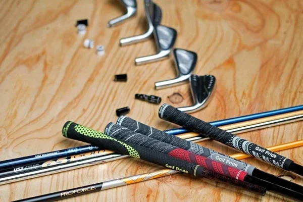 Golf grips, shafts, and irons arranged for custom golf club fitting.