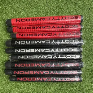 Assorted Scotty Cameron putter grips in red and black displayed on artificial turf.